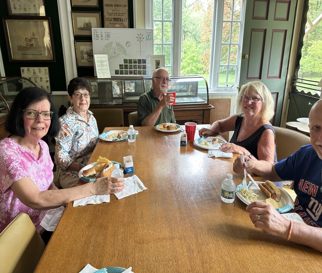 Union County Historical Society members seated near a window for the indoor annual picnic.
