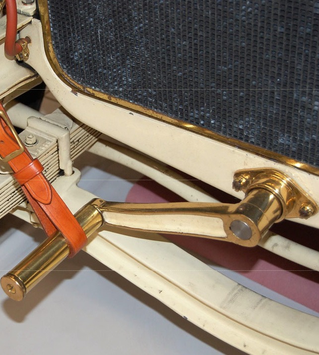 Brass hand crank used to start an early automobile engine before the invention of electric starters.