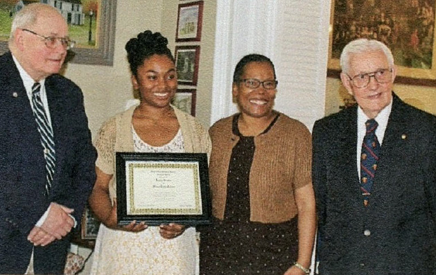 Rabia Brown of Union High School receiving a UCHS student history award at the Hanson House with family present.