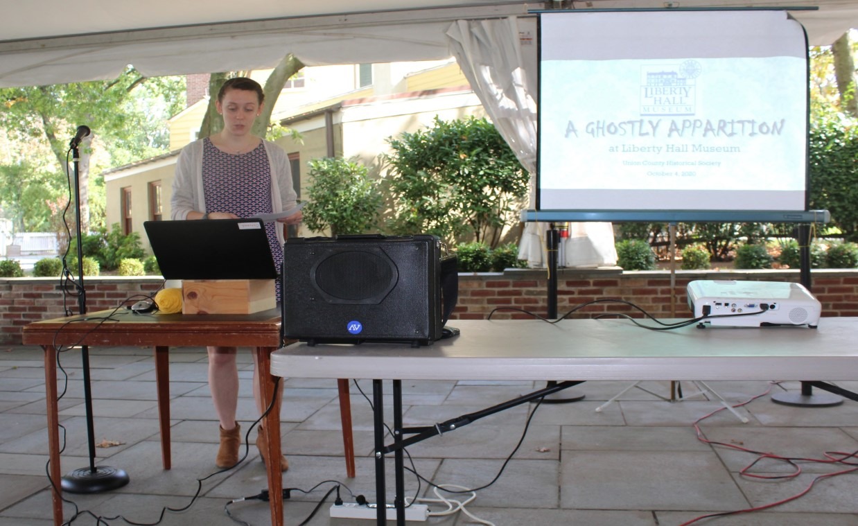 Hannah Gaston presenting the “A Ghostly Apparition” program at Liberty Hall Museum under an outdoor tent.