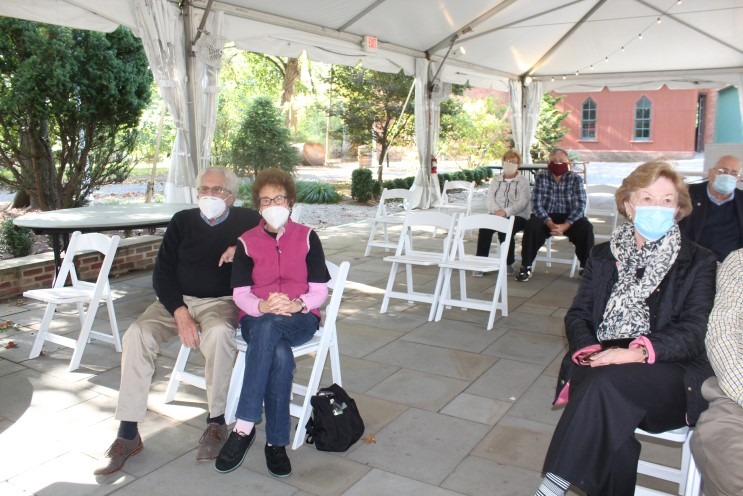Union County Historical Society members wearing masks and seated in socially distanced family groups under a white tent at Liberty Hall Museum.