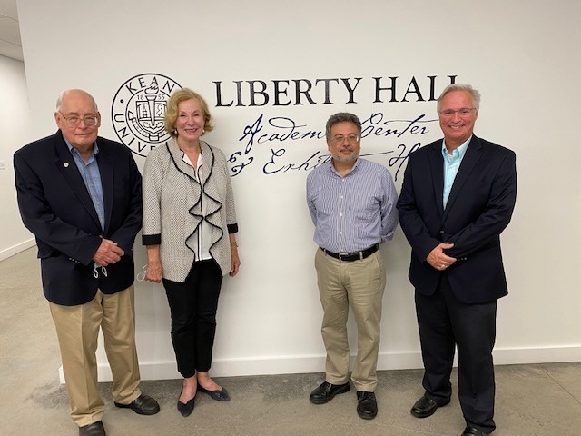Charles Shallcross, UCHS President Joanne Rajoppi, Dr. Christopher Bellitto, and John Prescott standing in front of the Liberty Hall Academic Center sign
