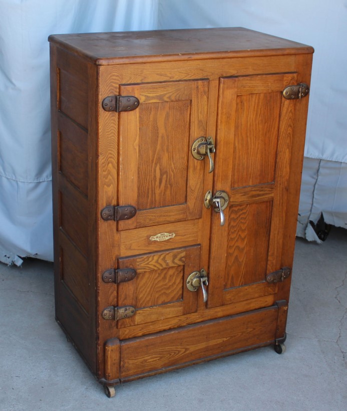 Antique quarter-sawn oak icebox with nickel-plated hinges and handles, typical of early twentieth-century home refrigeration