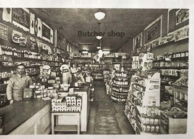 Historic interior photo of a butcher shop with stocked shelves and counters